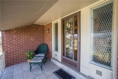 Inviting front porch accented by tile floor, storm