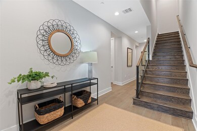 Stairway featuring wood finished floors and recessed lighting