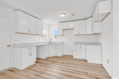 Kitchen featuring white cabinets, light countertop