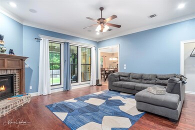 Living room with a brick fireplace, dark hardwood 