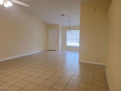 Unfurnished room with light tile patterned flooring and a chandelier