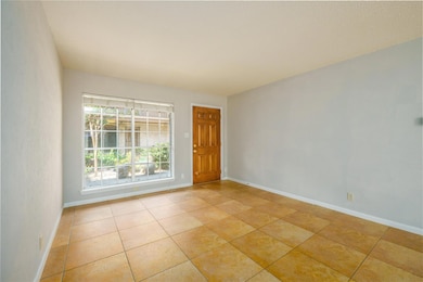 Ample sized freshly painted living room. Tile floors. Looks out to courtyard garden.