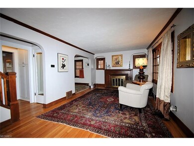 Living room features crown molding, hardwood floors and fireplace.