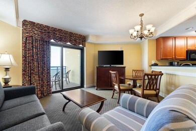 Carpeted living room featuring a chandelier and a 