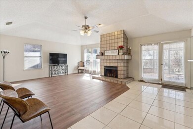 Living room featuring a fireplace, ceiling fan, NE