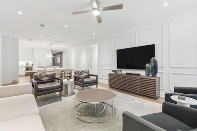 Living room featuring a decorative wall, light wood finished floors, recessed lighting, wine cooler, and ceiling fan