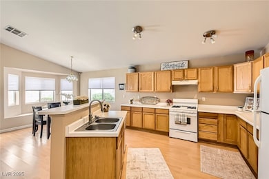 Kitchen with white appliances, stove/oven, a sink