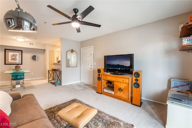 Living room with carpet, a ceiling fan, and basebo
