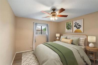 Bedroom with baseboards, wood finished floors, a 
