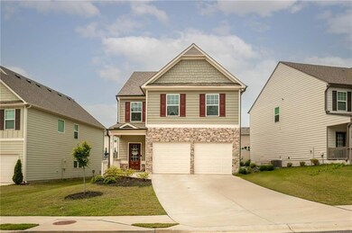 Craftsman house with stone siding, concrete driveway, an attached garage, and a front lawn