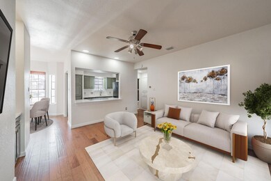 Living room featuring ceiling fan and light wood-t