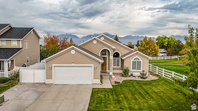 View of front facade featuring a mountain view, stucco siding, concrete driveway, and an attached garage