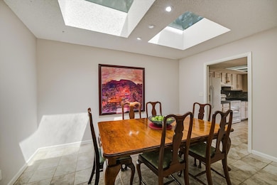 Dining area featuring recessed lighting, a skylight, a textured ceiling, and light tile patterned floors