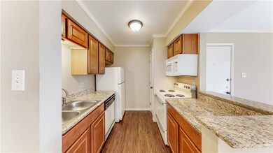Kitchen featuring brown cabinets, wood finished fl