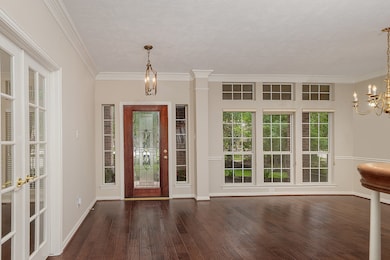 The formal dining room is infused with natural light and wooded views