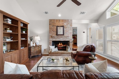 Living area with a ceiling fan, dark wood finishe