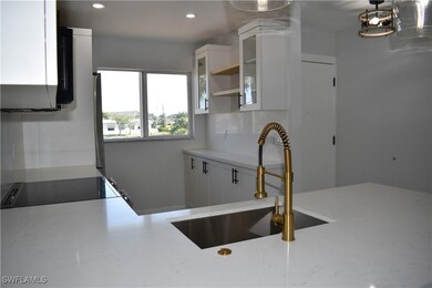 Kitchen featuring cooktop, a sink, light stone cou