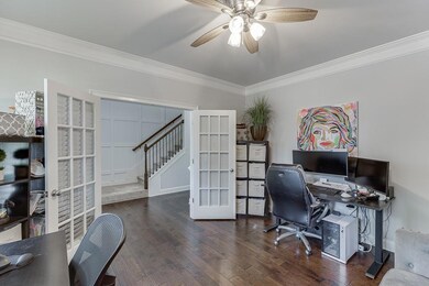Office area with french doors, crown molding, ceiling fan, and wood finished floors