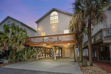Back of house featuring a carport, driveway, and a