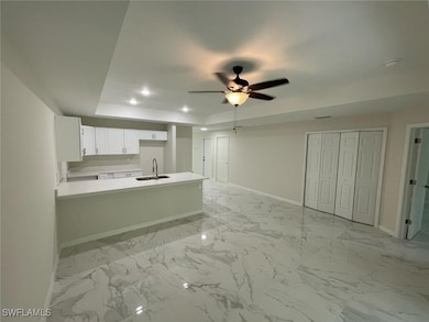 Kitchen with baseboards, a raised ceiling, a penin