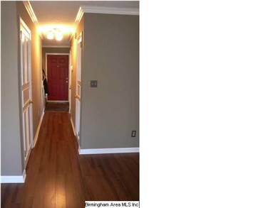 Hallway has beautiful hardwood flooring.