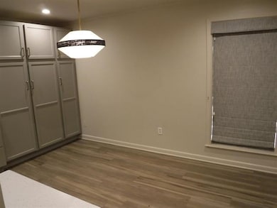 Unfurnished dining area featuring dark wood-type flooring and recessed lighting