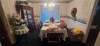 Dining space with a wainscoted wall, wallpapered w