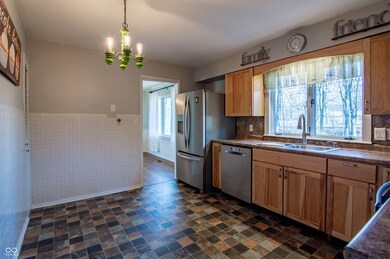 kitchen with a sink, decorative light fixtures, dark countertops, and appliances with stainless steel finishes