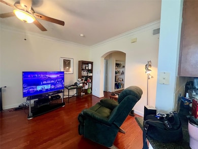 Living room featuring arched walkways, crown mold