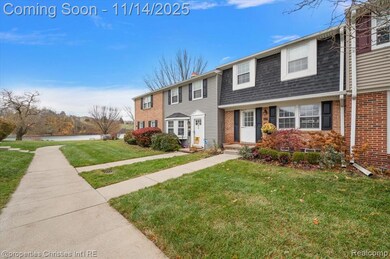 View of front of property with brick siding, a front yard, and roof with shingles
