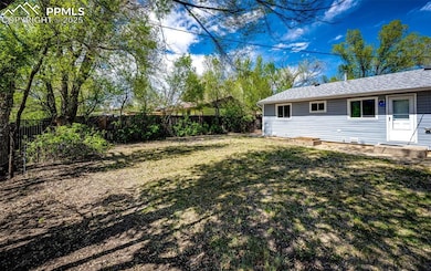 View of front of property with fence, a front yard, and a vegetable garden