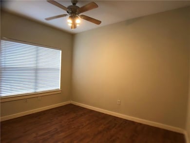 Spare room featuring a ceiling fan and dark wood-style floors