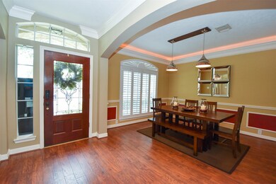 Walking into  the entry of the home on your left you will find a spacious dining room with crown molding, recessed lighting, shutters and beautiful wood laminate floors.