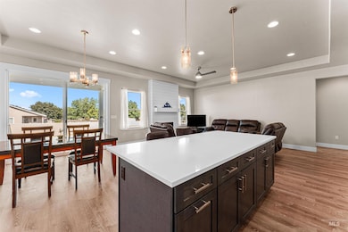 Kitchen featuring a raised ceiling, light wood-style floors, light countertops, and recessed lighting