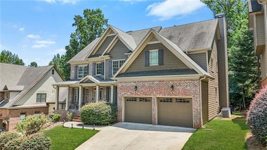 Craftsman house featuring brick siding, driveway, a front yard, an attached garage, and a porch