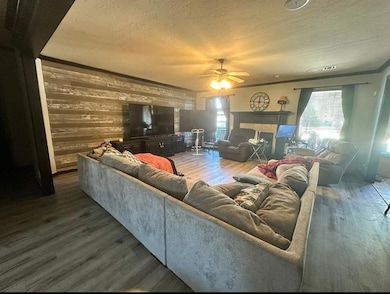 Living room with ceiling fan, a multi sided firepl