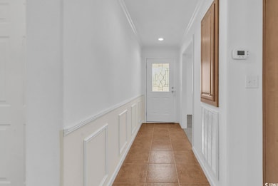 Doorway featuring ornamental molding and recessed lighting