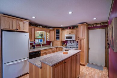 Center island kitchen has hickory cabinets with pu