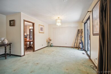 Carpeted empty room with an inviting chandelier