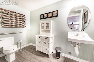 Bathroom with toilet, baseboards, and wood finishe