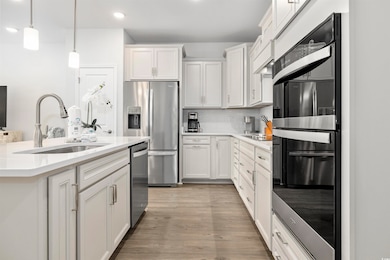 Kitchen featuring decorative backsplash, recessed lighting, light countertops, a sink, and stainless steel appliances