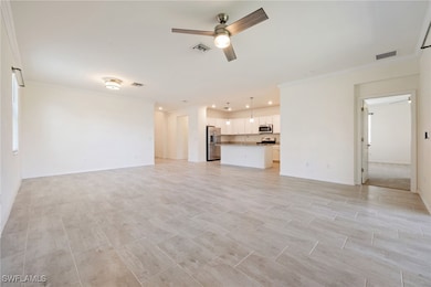 Unfurnished living room featuring a ceiling fan, c