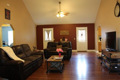 Living room with vaulted ceiling and double fans.
