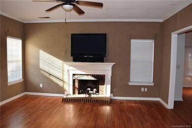 Den features gas log fireplace, ceiling fan and mo