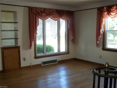 Living room has hardwood floor and built-in shelvi