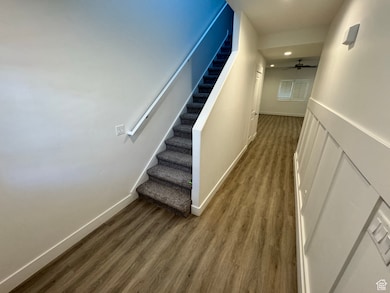 Corridor featuring stairs, wood finished floors, and recessed lighting