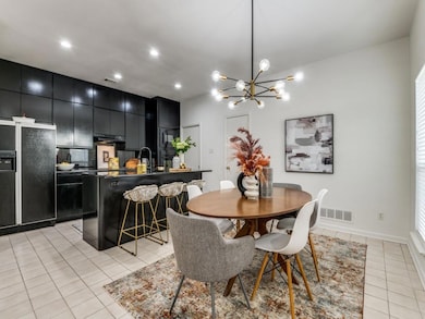 Dining area with a notable chandelier opens to Kit