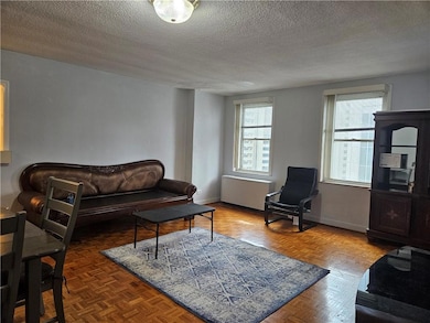 Living room featuring a textured ceiling and radiator