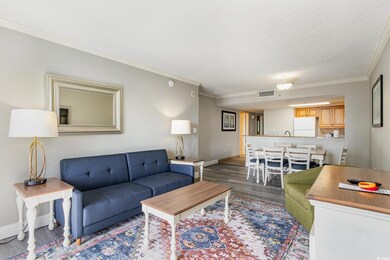 Living area featuring crown molding, dark wood fin