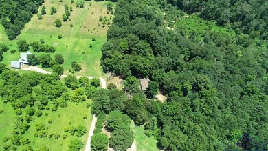 View of property location with a heavily wooded area